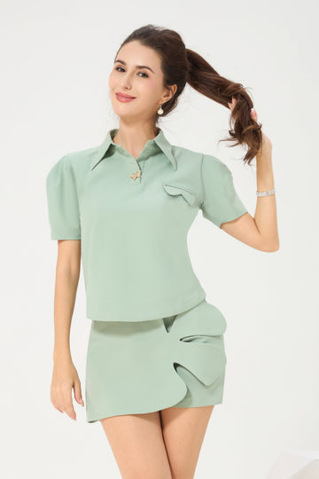 Model wearing a mint green Vanda Modes bottoms called skort, featuring Vanda Modes's signature vanda floral motif details and tailored fit - a blend of playful elegance and smart comfort.